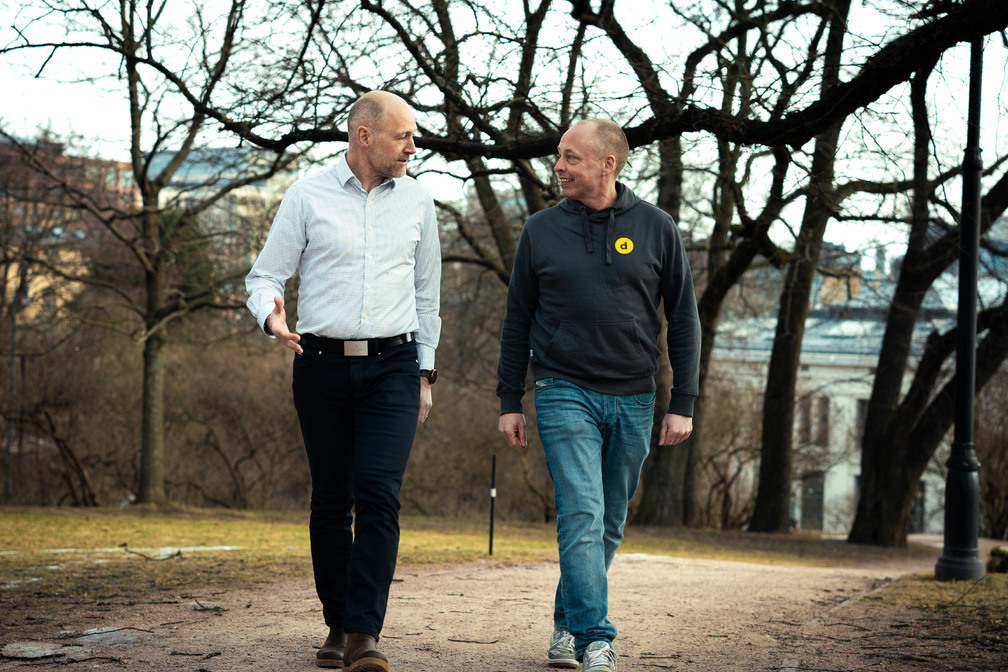 to menn som går tur i en park mens de snakker sammen